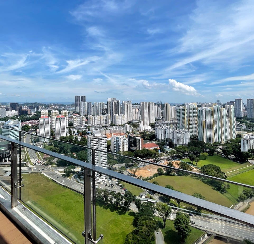 Two teenagers focus intently on a device outdoors, surrounded by nature.
